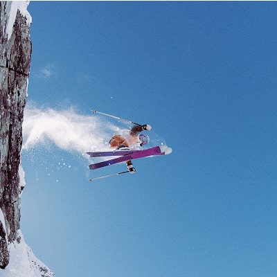 A freeskier jumping from a cliff